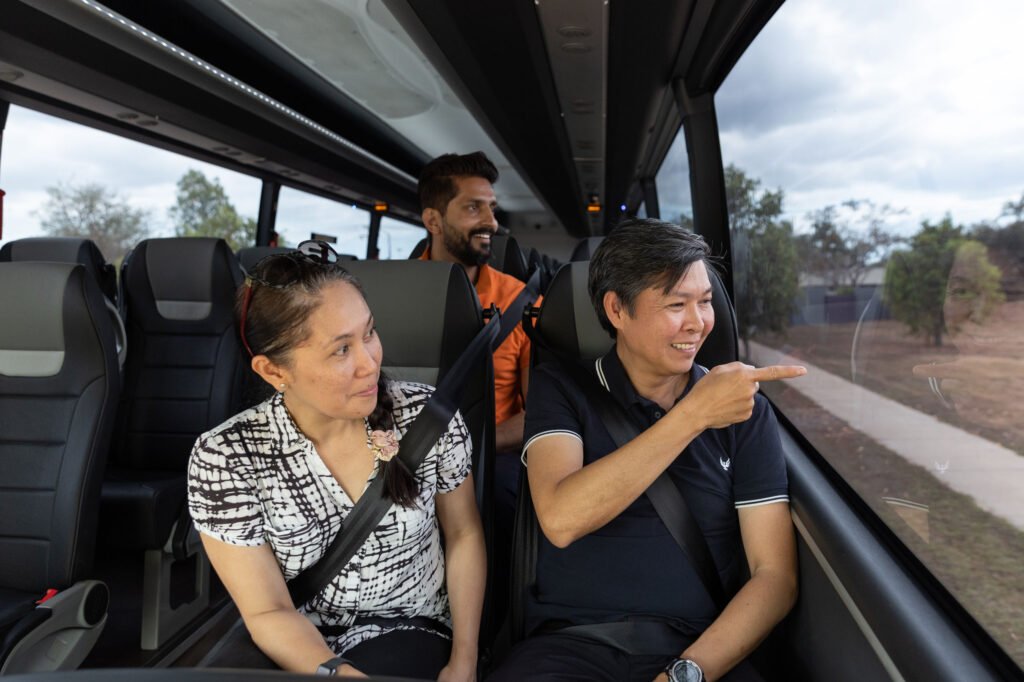 Passengers smiling in CDC NT charter the bus