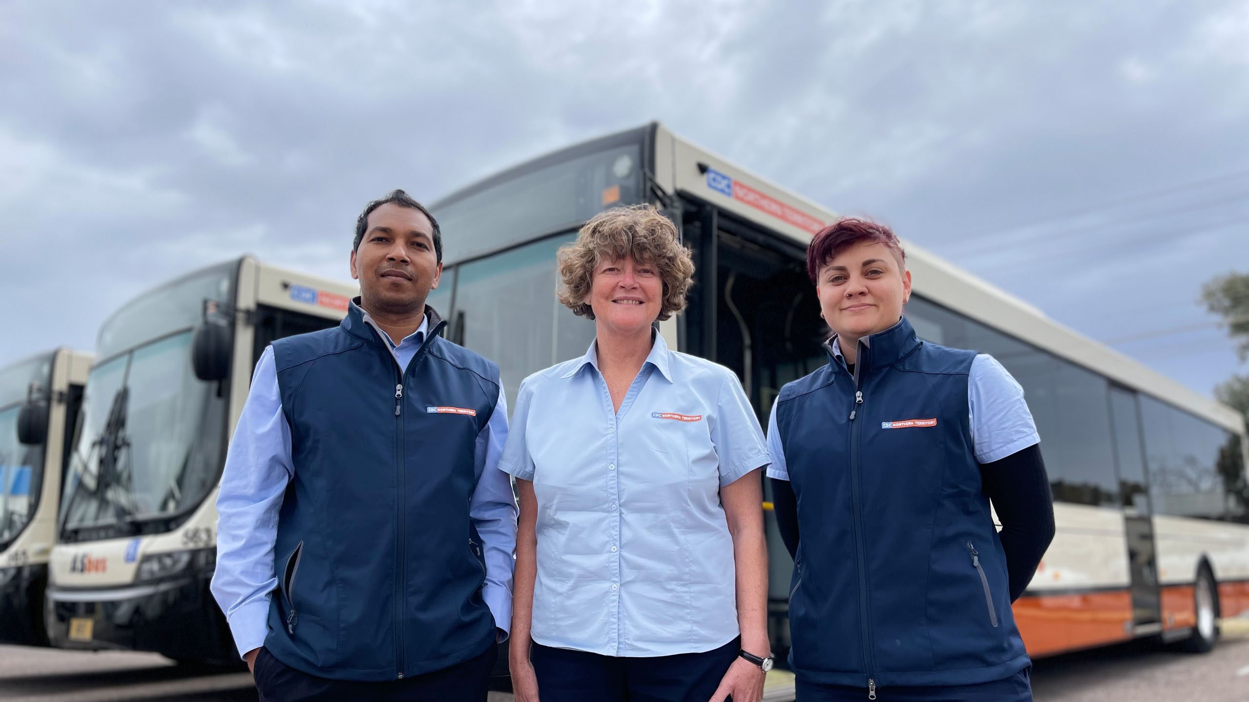 CDC NT Staff Smiling in front of buses